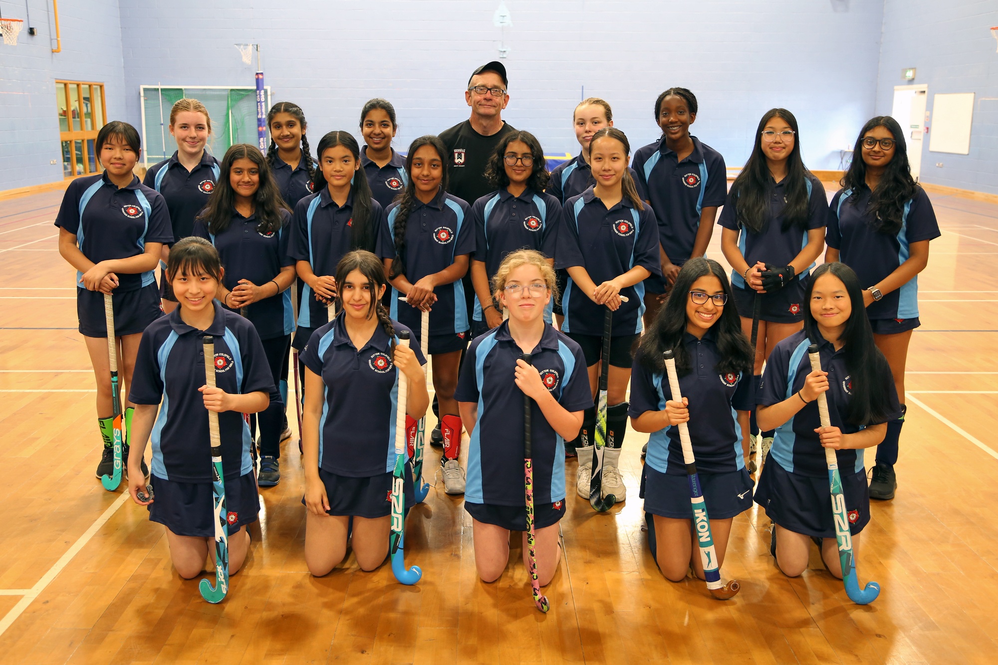 Students of the hockey club surround celebrated coach, Dave O'Brien